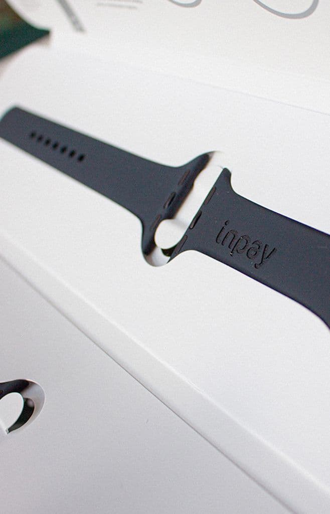 a black inpay watch sits in a white box