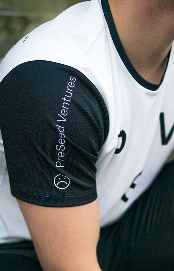 a man wearing a shirt that says presed ventures on the sleeve.